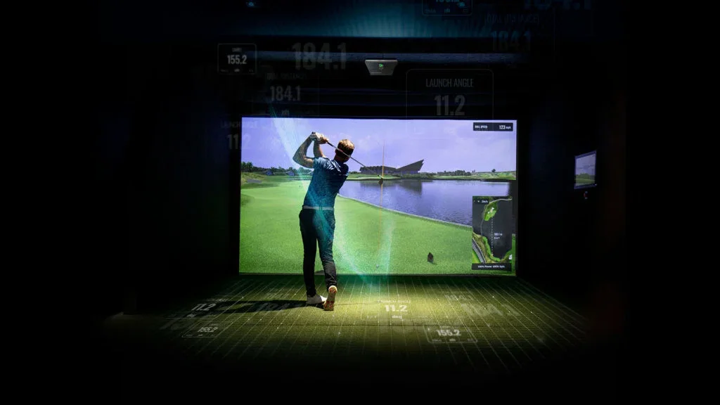Trackman iO を天井に設置したインドア打席で、スクリーンに向かってスイングしている様子